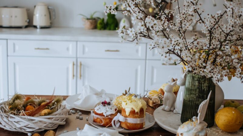 Elegant Easter table setup with cakes and blooming branches in a modern kitchen.